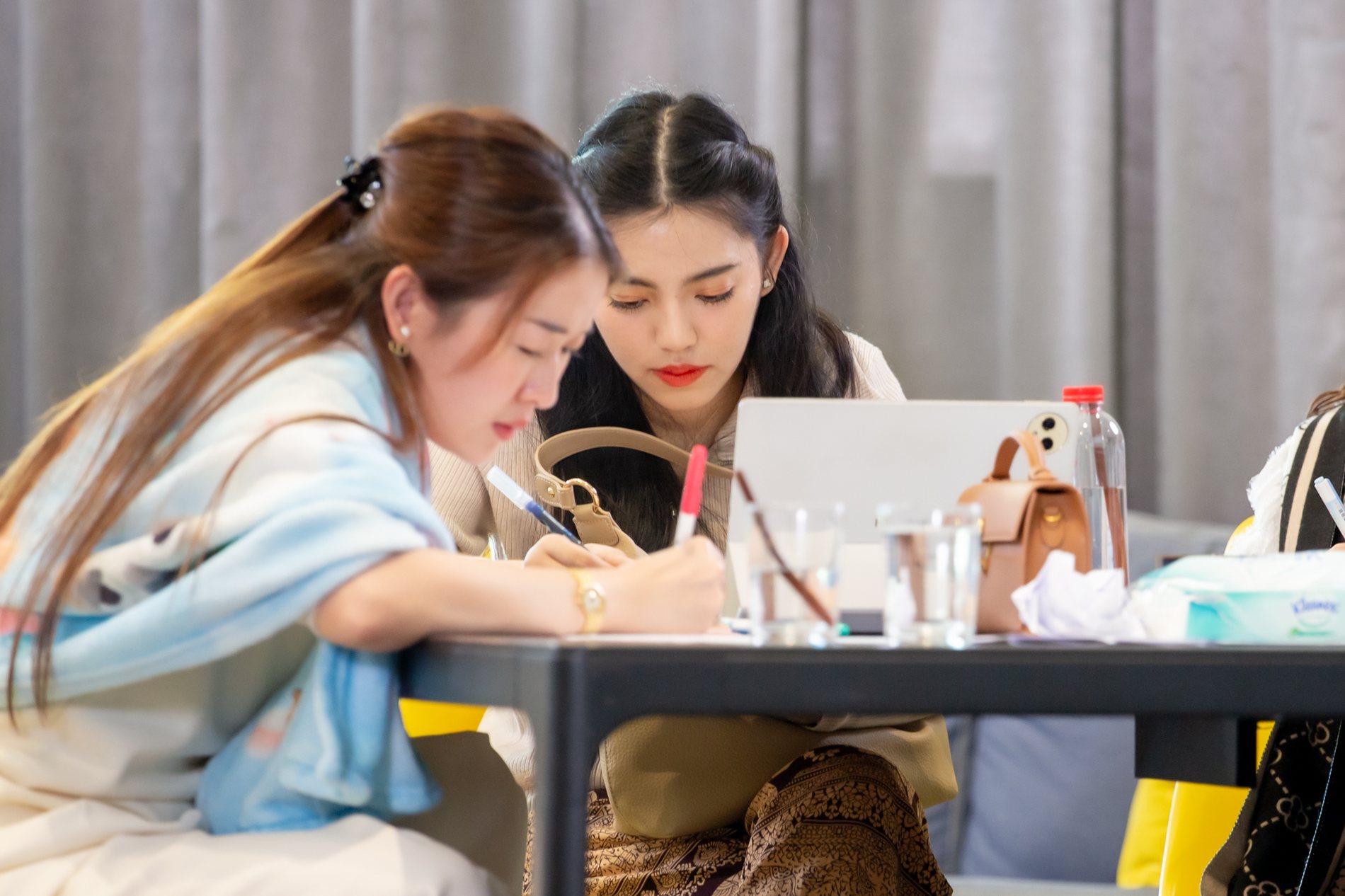 ผู้เรียนสองคนกำลังเขียนงานด้วยกัน